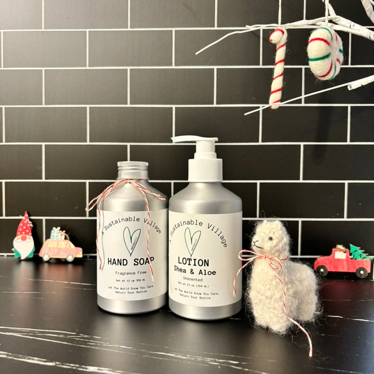 Two bottles of Sustainable Village hand soap and lotion on a black tiled wall background with decorative items.  Zero waste lifestyle gift set