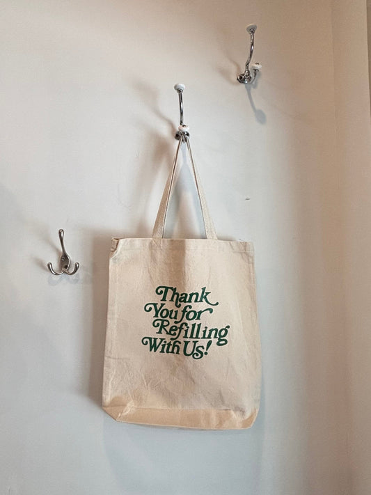 Tote bag with text hanging on a wall with hooks
