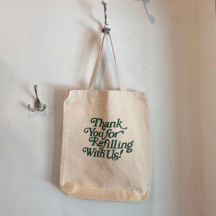 Tote bag with text hanging on a wall with hooks